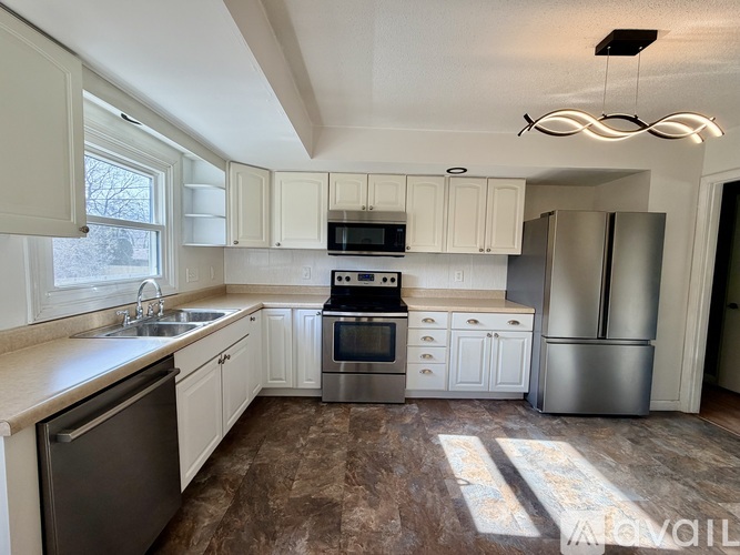 A kitchen with white cabinets and stainless steel appliances.