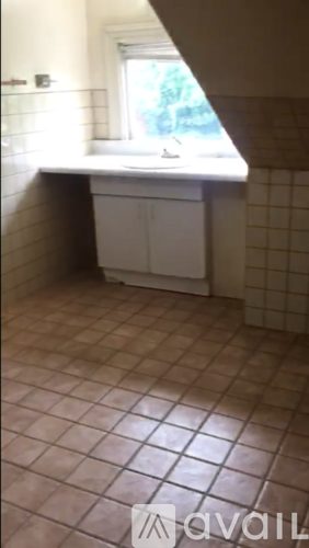 A bathroom with a tiled floor and a window.