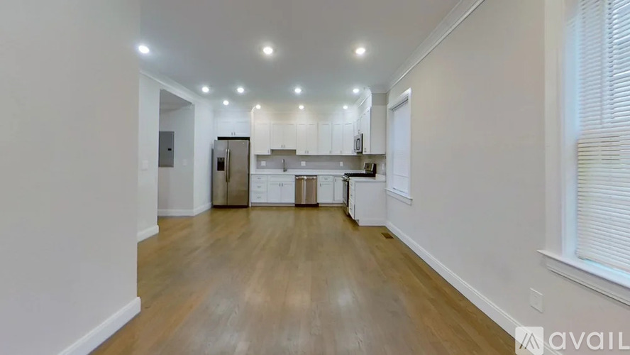 A kitchen with white cabinets and a wooden floor.
