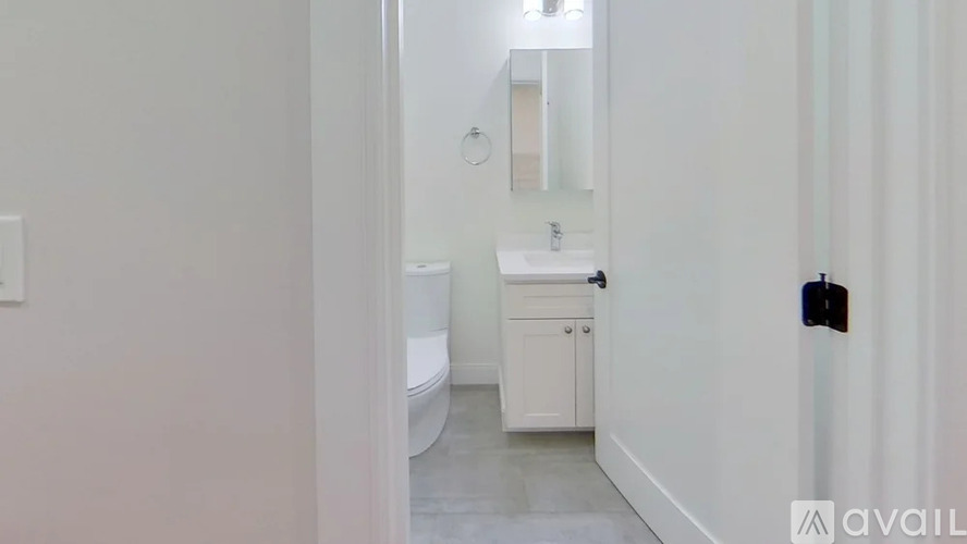 A bathroom with a toilet, sink, and mirror.