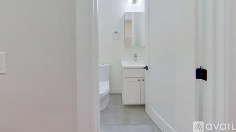 A bathroom with a toilet, sink, and mirror.