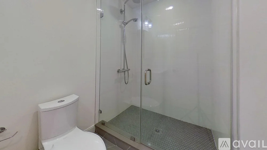 A white toilet sits next to a glass shower stall.