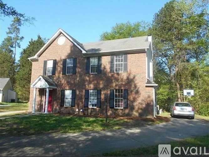 A brick house with a car parked in front.