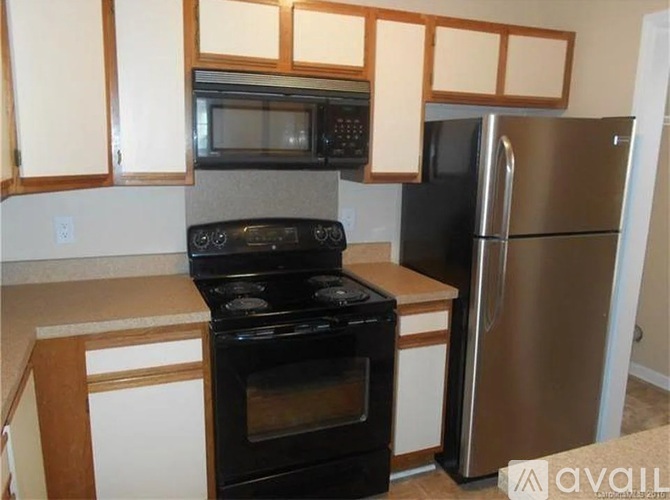 A kitchen with a black oven and a black microwave above it.