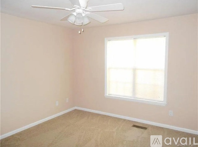 A room with a ceiling fan and a window.