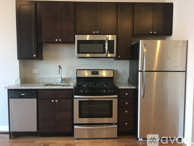 A kitchen with a stove, oven, microwave, and refrigerator.