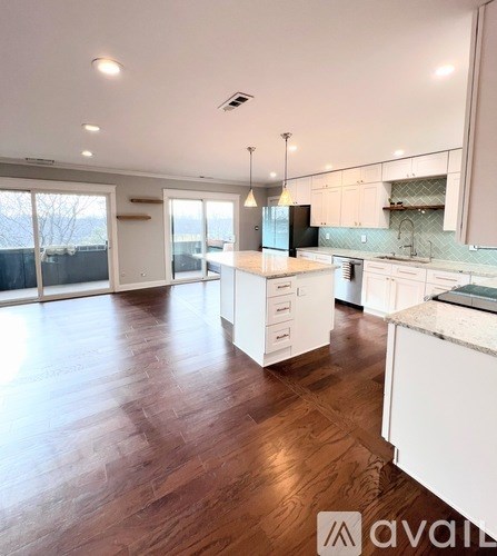 A kitchen with white cabinets and a wooden floor.