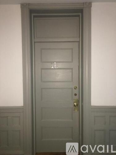 A white door with a brass handle and a small window above the handle.