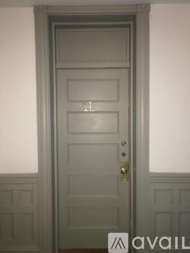 A white door with a brass handle and a small window above the handle.