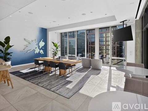 A modern dining room with a long table and chairs.