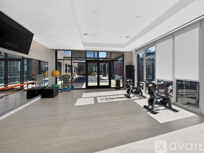 A spacious room with exercise equipment and large windows.