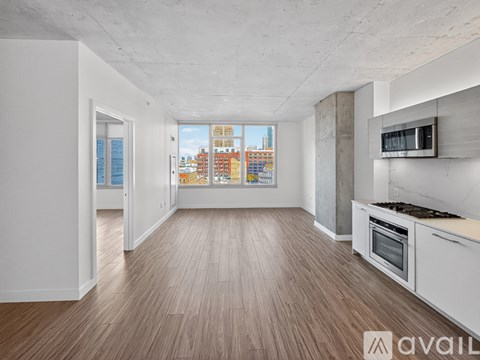 A spacious kitchen with wooden flooring and modern appliances.