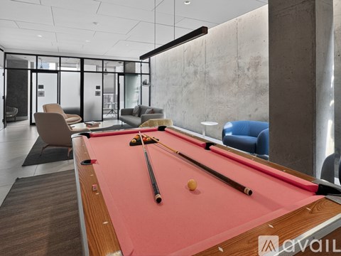 A pool table in a room with a brown carpet.