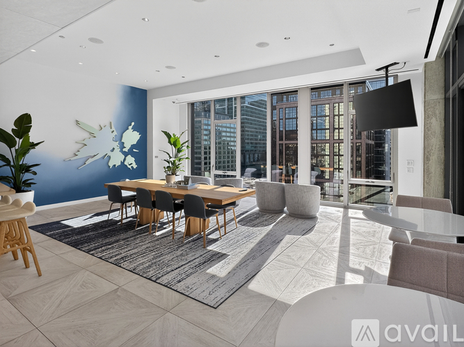A modern dining room with a long table and chairs.