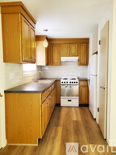 A kitchen with wooden cabinets and a white refrigerator.