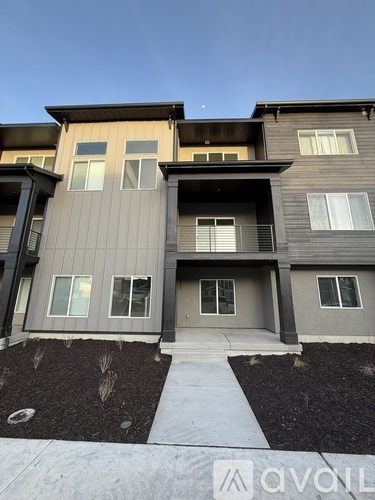 A modern two-story building with a balcony and a walkway in front.