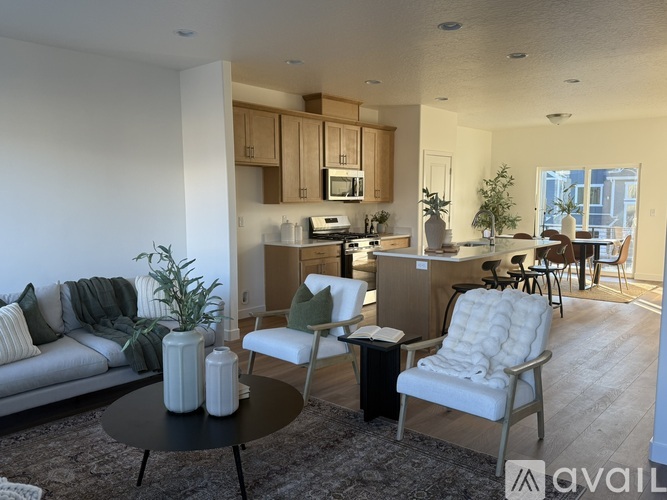 A living room with a grey sofa, a black coffee table, and a white chair.