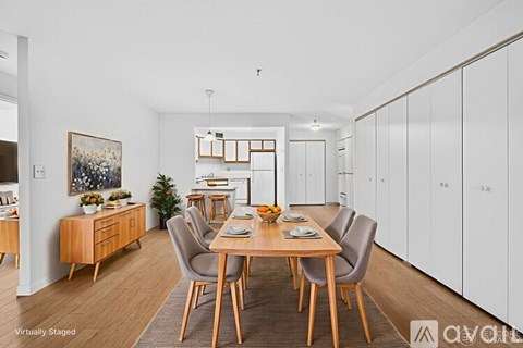 A dining room with a wooden table and chairs.