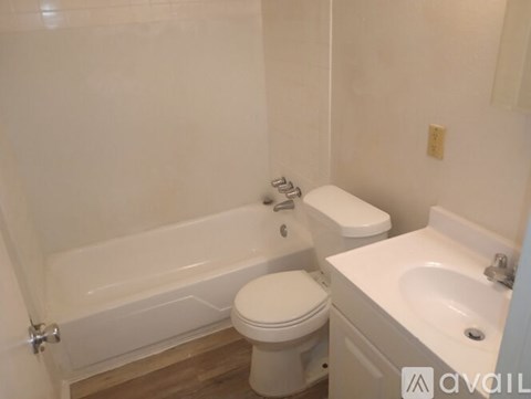 A white toilet sits next to a white sink in a bathroom.