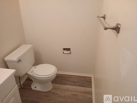 A white toilet and sink in a small bathroom.