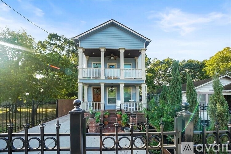 A blue house with a black fence in front.