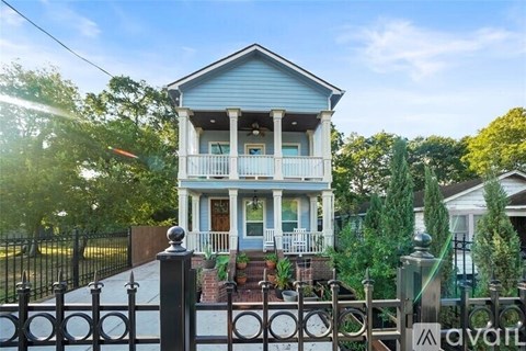 A blue house with a black fence in front.