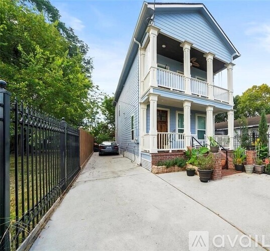 A two-story house with a blue exterior and a black fence.