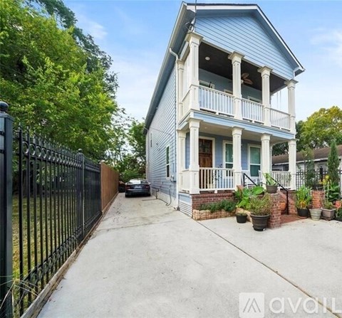 A two-story house with a blue exterior and a black fence.