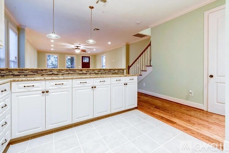 A kitchen with white cabinets and a tile floor.