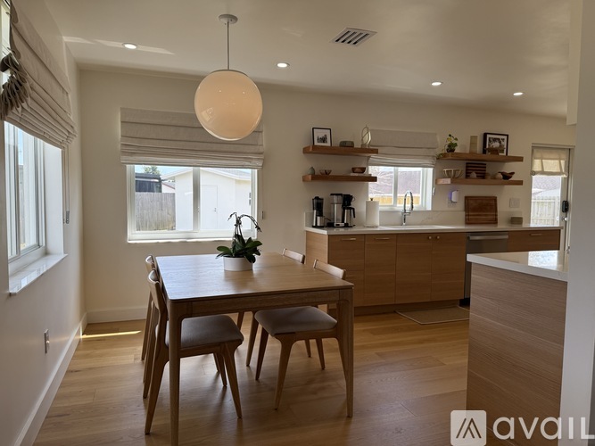 A modern kitchen with a dining table and chairs.