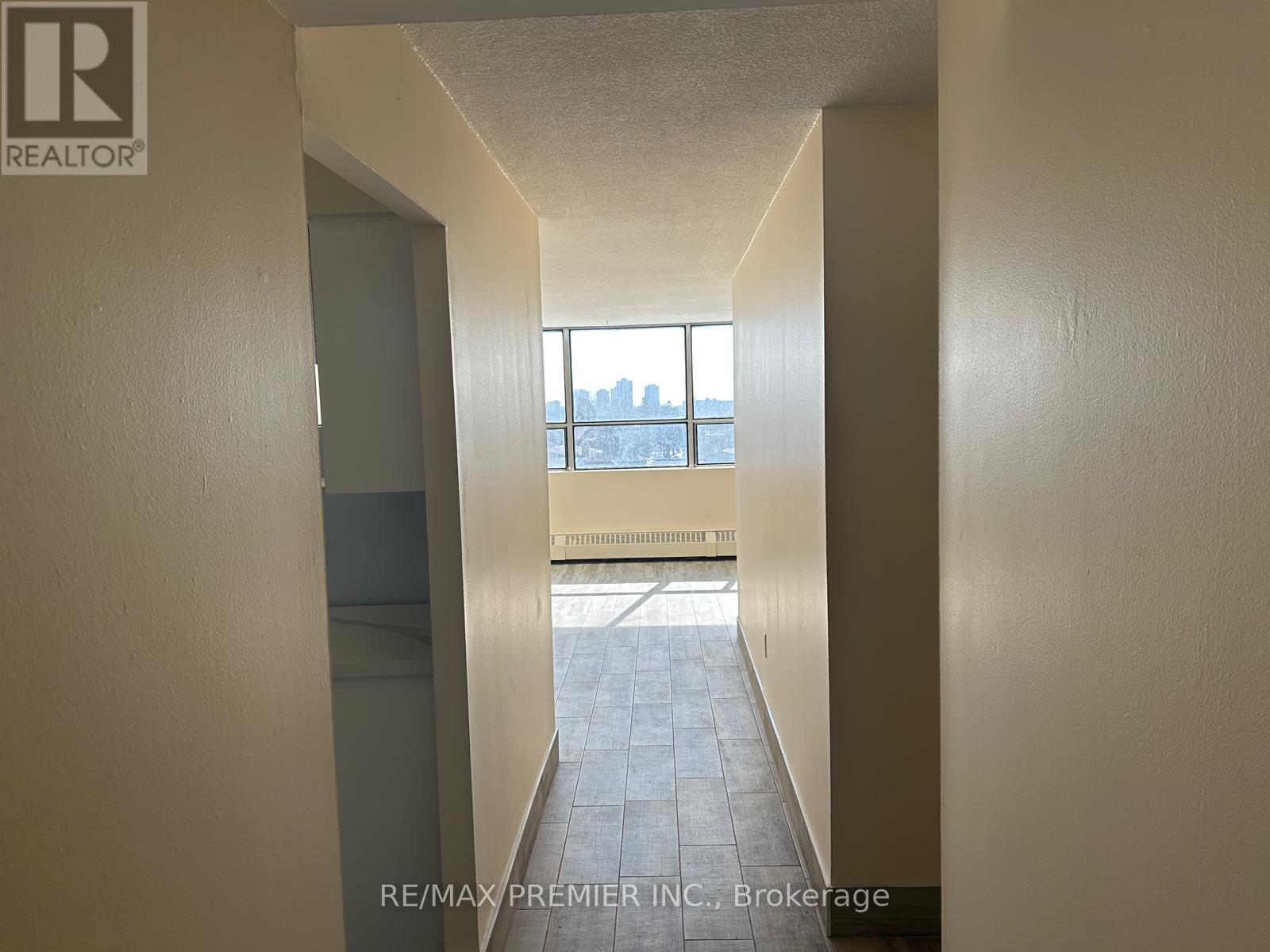 A hallway with a window that has a view of a city.