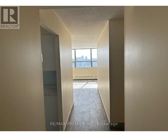 A hallway with a window that has a view of a city.