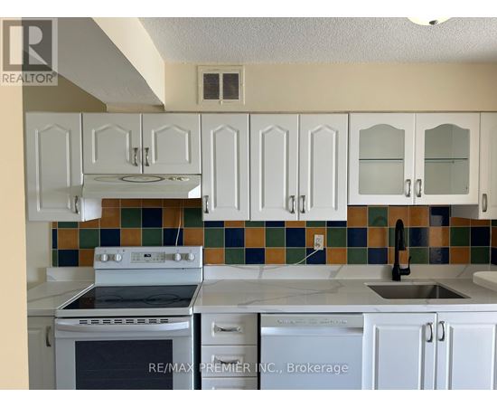 A kitchen with white cabinets and a stove top oven.
