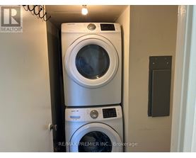 A stack of two washing machines in a small space.