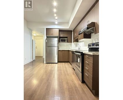 A modern kitchen with wooden cabinets and stainless steel appliances.