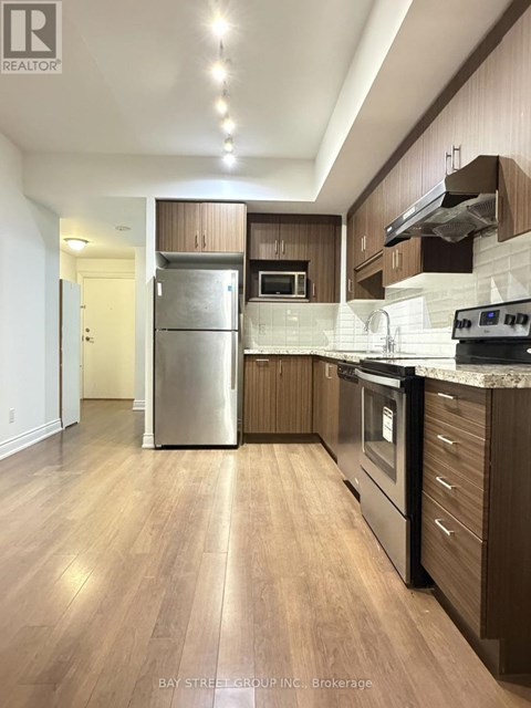 A modern kitchen with wooden cabinets and stainless steel appliances.
