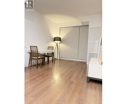 A room with a table and chairs and a lamp.