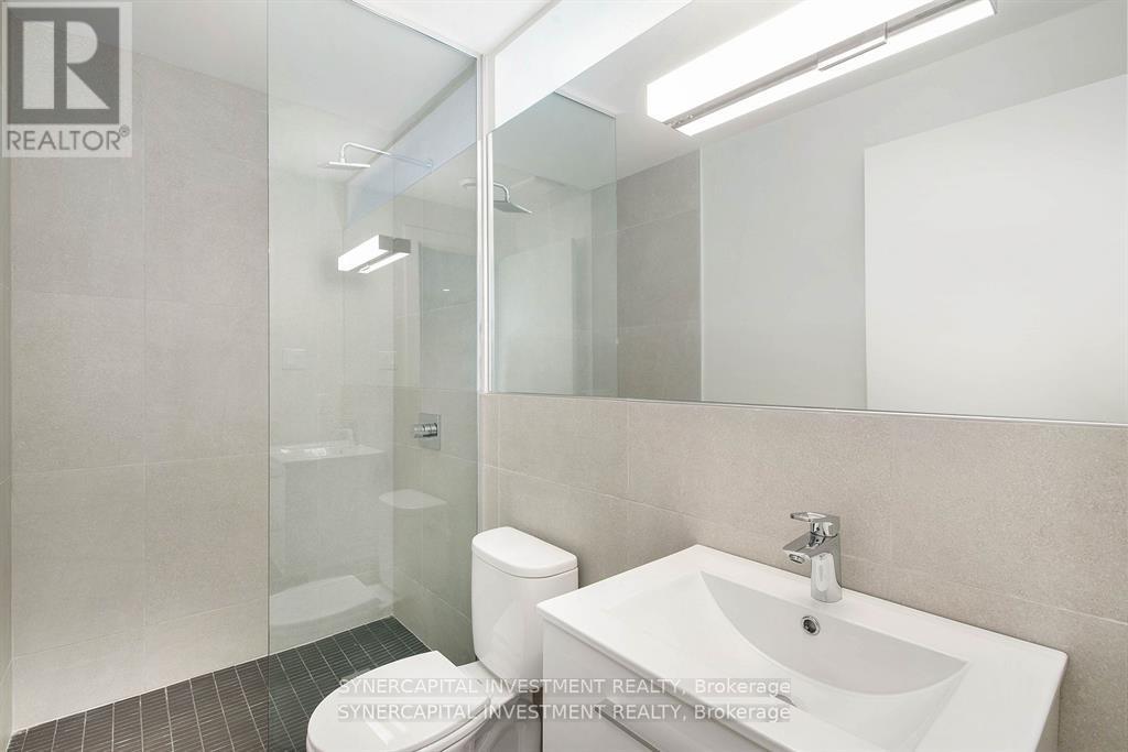 A bathroom with a sink, toilet, and shower.