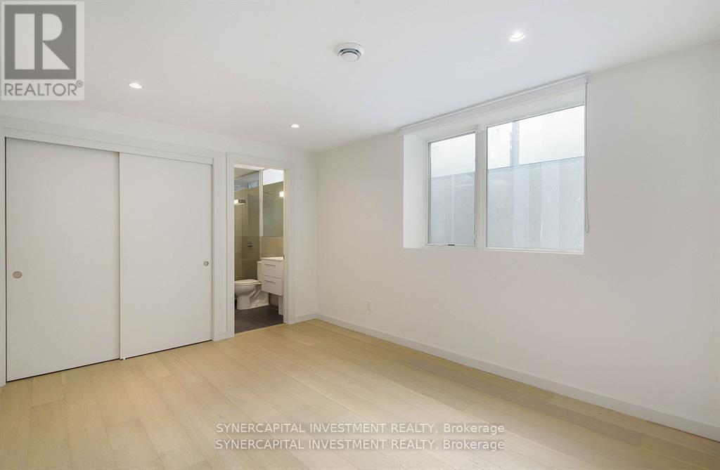 A white bedroom with a sliding door and a window.