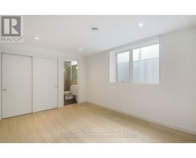A white bedroom with a sliding door and a window.
