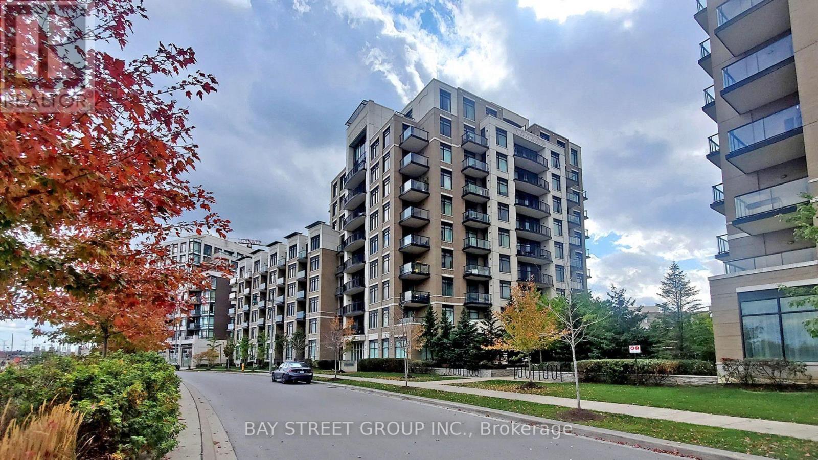 A street view of a residential area with apartment buildings and trees.