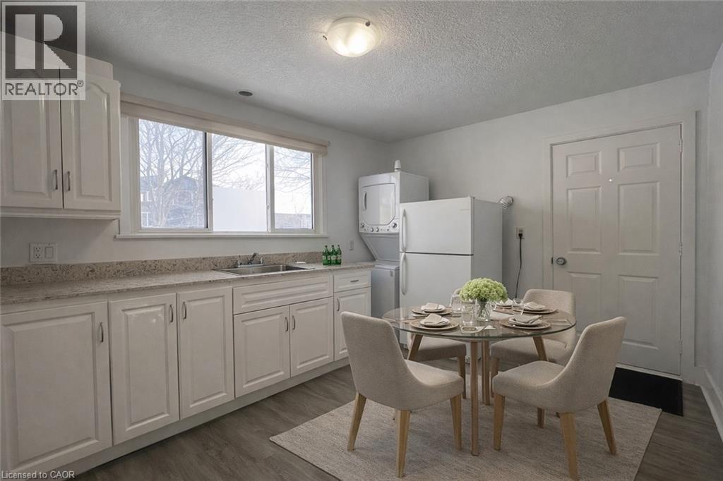 A kitchen with a table set for two and a refrigerator.
