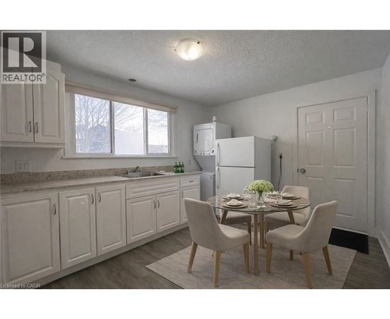 A kitchen with a table set for two and a refrigerator.