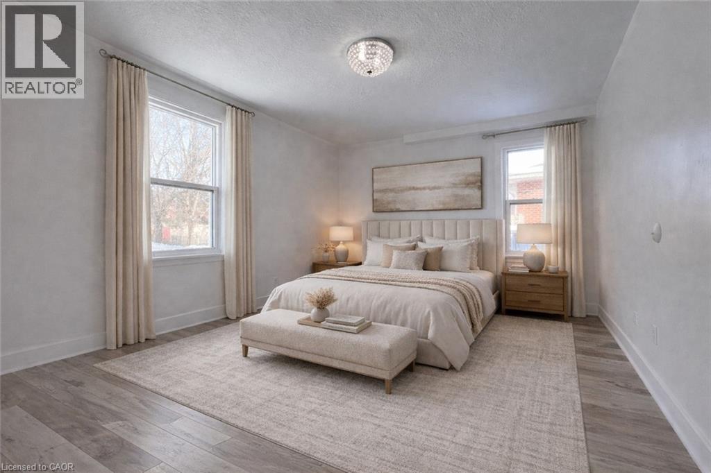A bedroom with a large bed and a window with curtains.