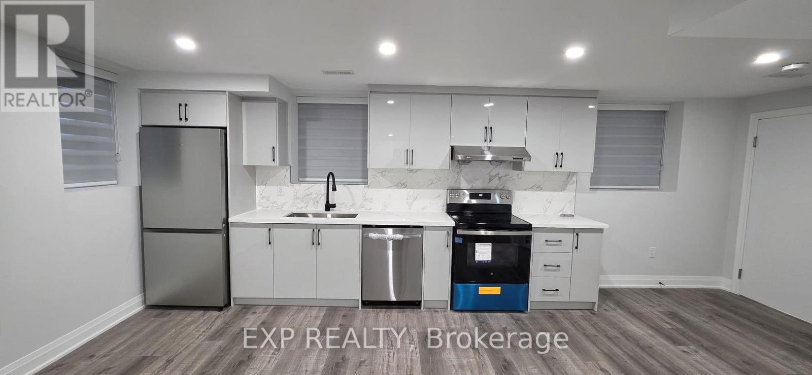 A modern kitchen with white cabinets and a blue dishwasher.