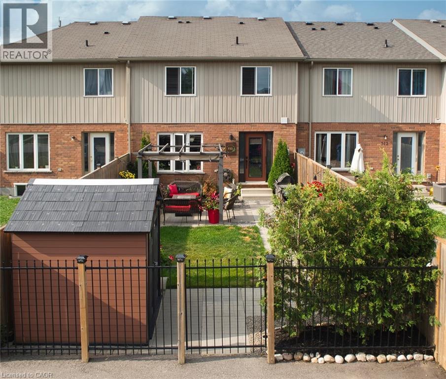 A large house with a black gate and a red car in front.