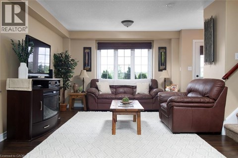 A living room with brown leather furniture and a white rug.