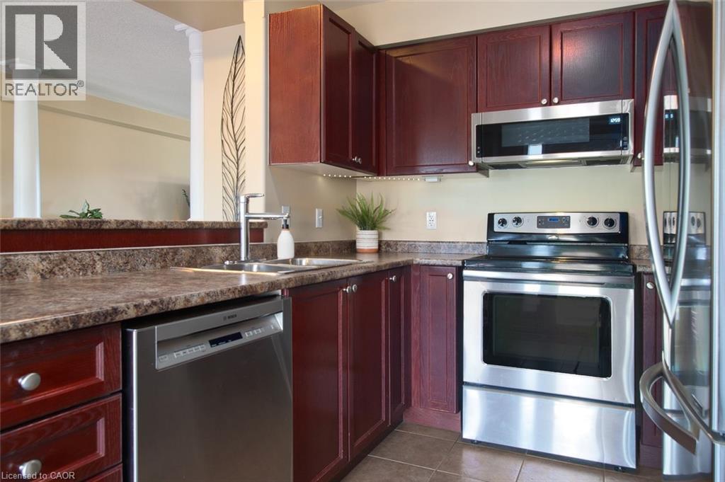 A kitchen with red cabinets and stainless steel appliances.
