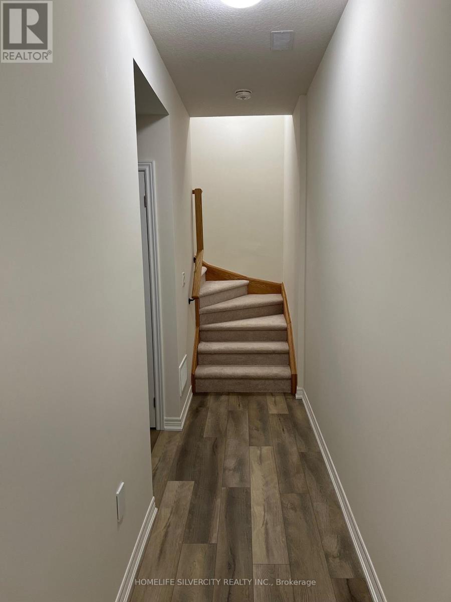A hallway with a staircase and wooden floors.