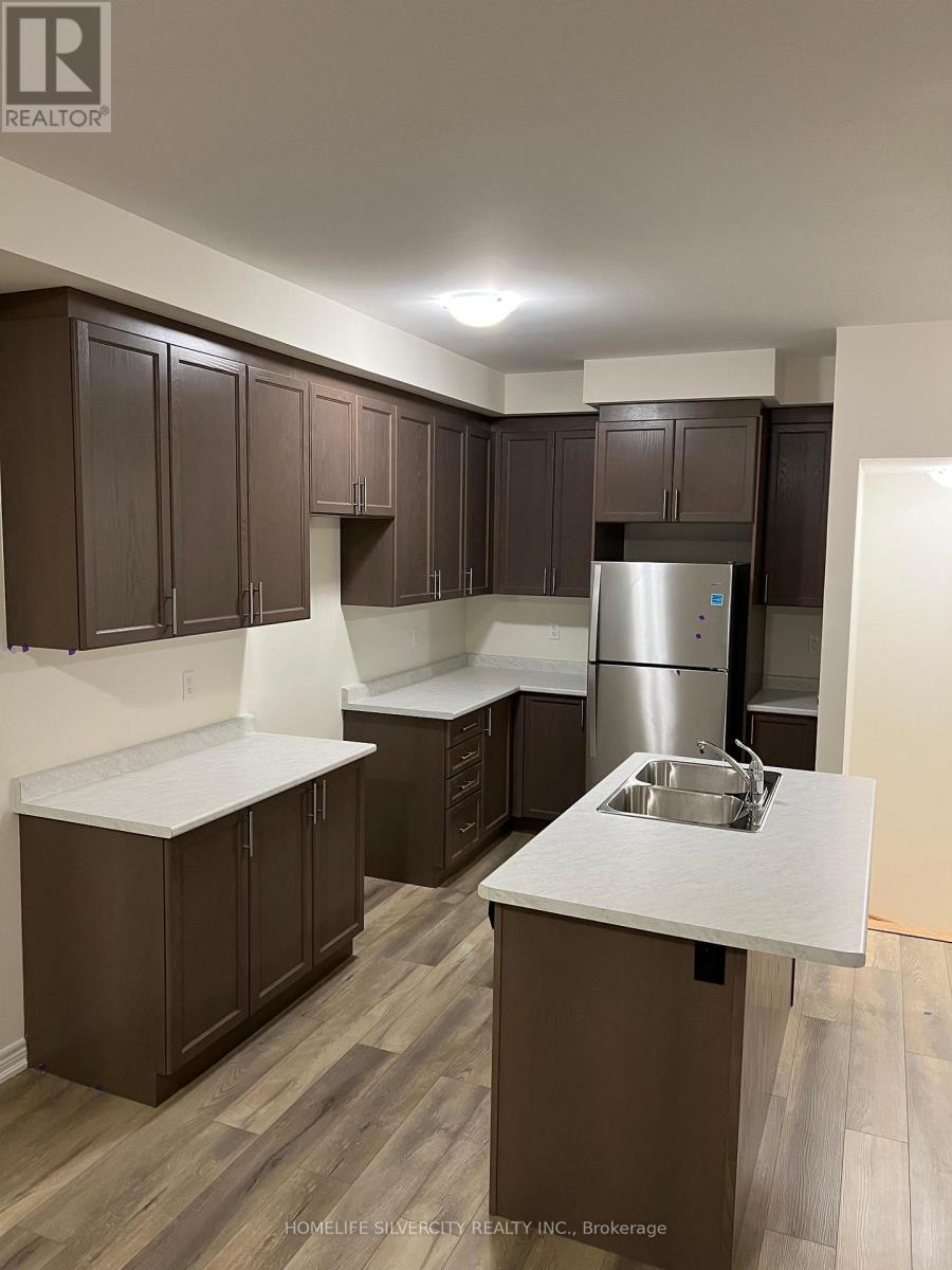 A kitchen with brown cabinets and a stainless steel refrigerator.